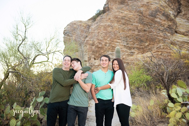 family hugging and laughing standing in the desert