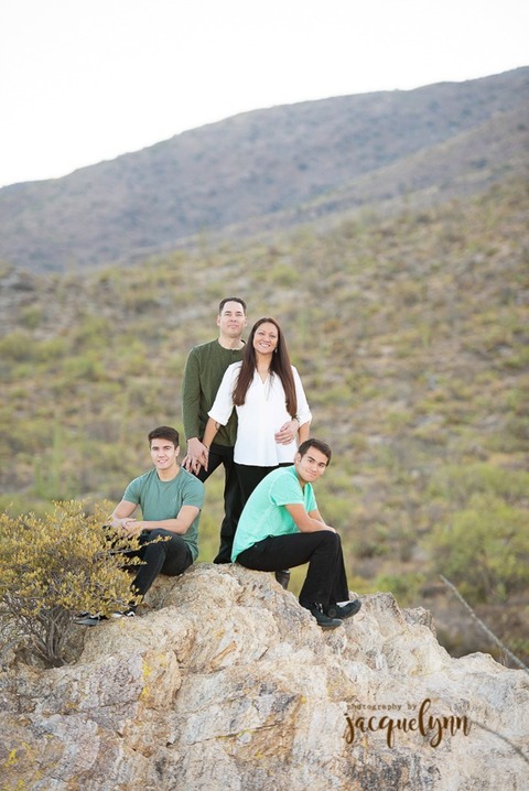 family standing on a rick in the desert in tucson