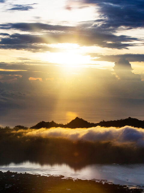 Sunrise view from Mt. Batur Bali Indonesia with clouds over the ground and water