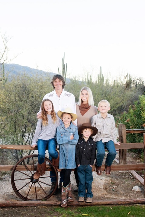morning at tanque verde ranch tucson family photo session family standing by wooden fence with saguaros in the background
