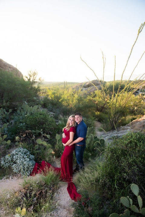 dramatic tucson maternity photo of pregnant woman in red dress and man in green desert