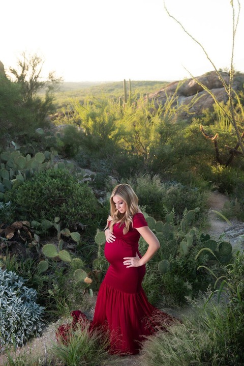 dramatic tucson maternity photo of pregnant woman in red dress in green desert