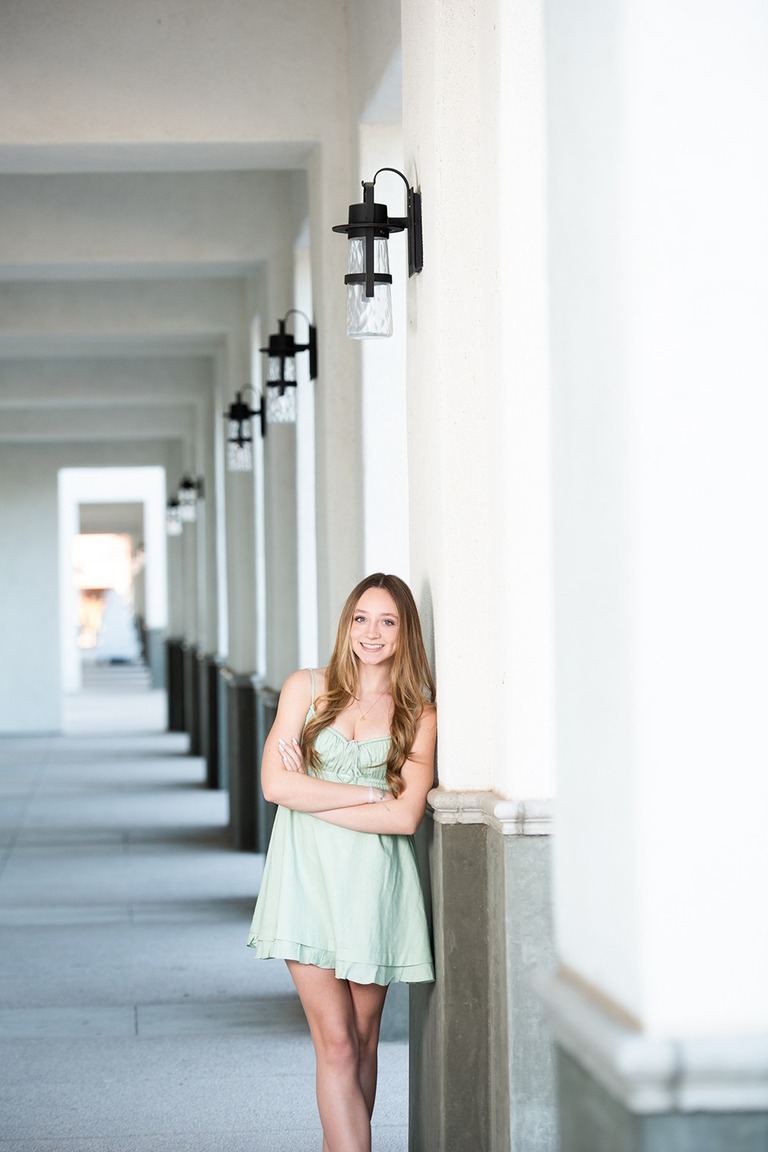 girl leaning against wall with columns